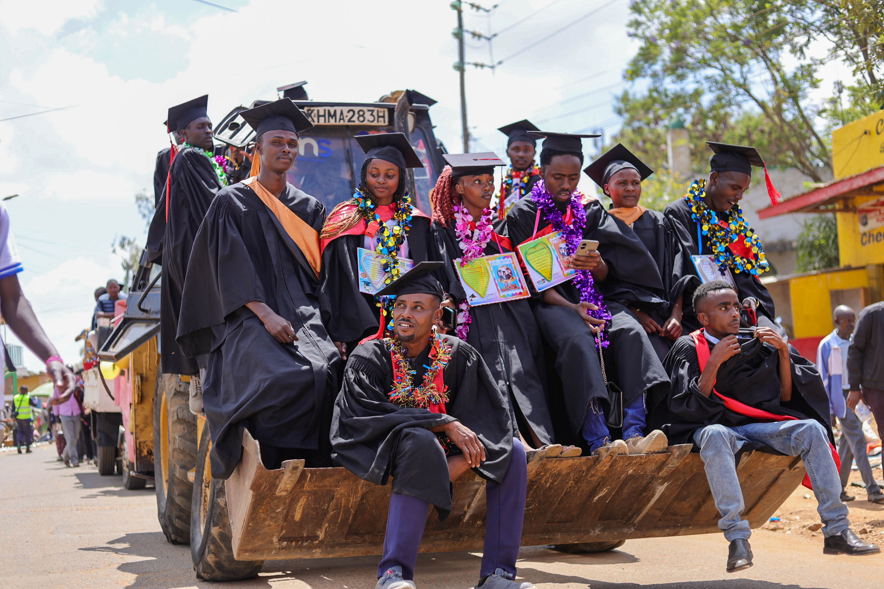 Backhoe carrying graduating students | Lion Cats